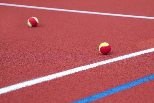 Red tennis ball on court
